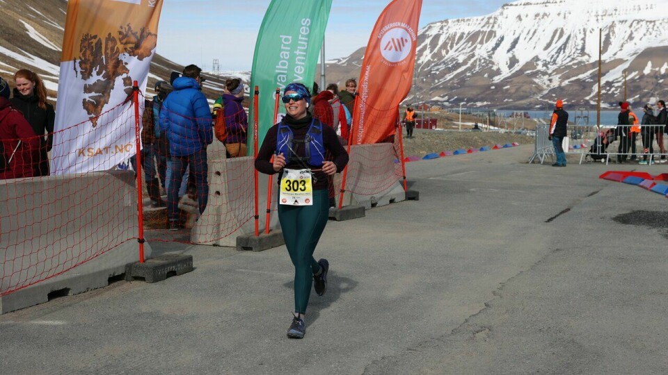 Marjolaine Verret løper i mål på halvmaraton under Spitsbergen Marathon 2023