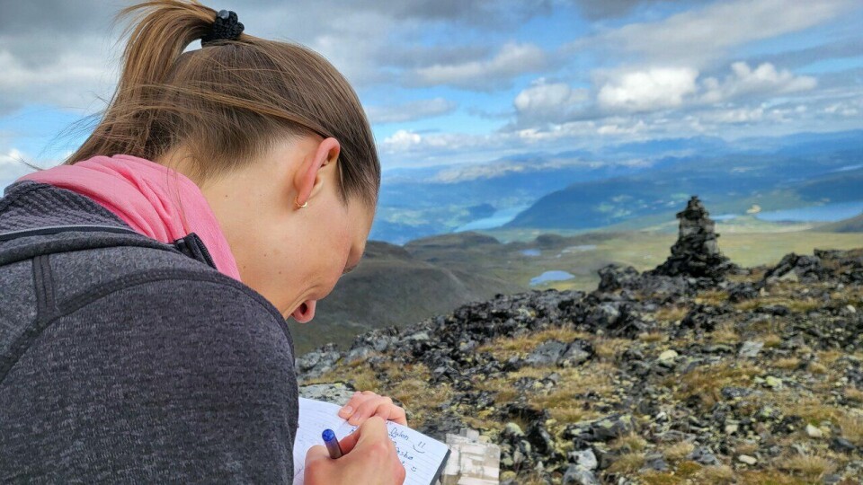 Topptur: Hanne skriver oss inn i boka på toppen av Gravåhøi i Lom. (Foto: Marianne Røhme) Topptur: Hanne skriver oss inn i boka på toppen av Gravåhøi i Lom.