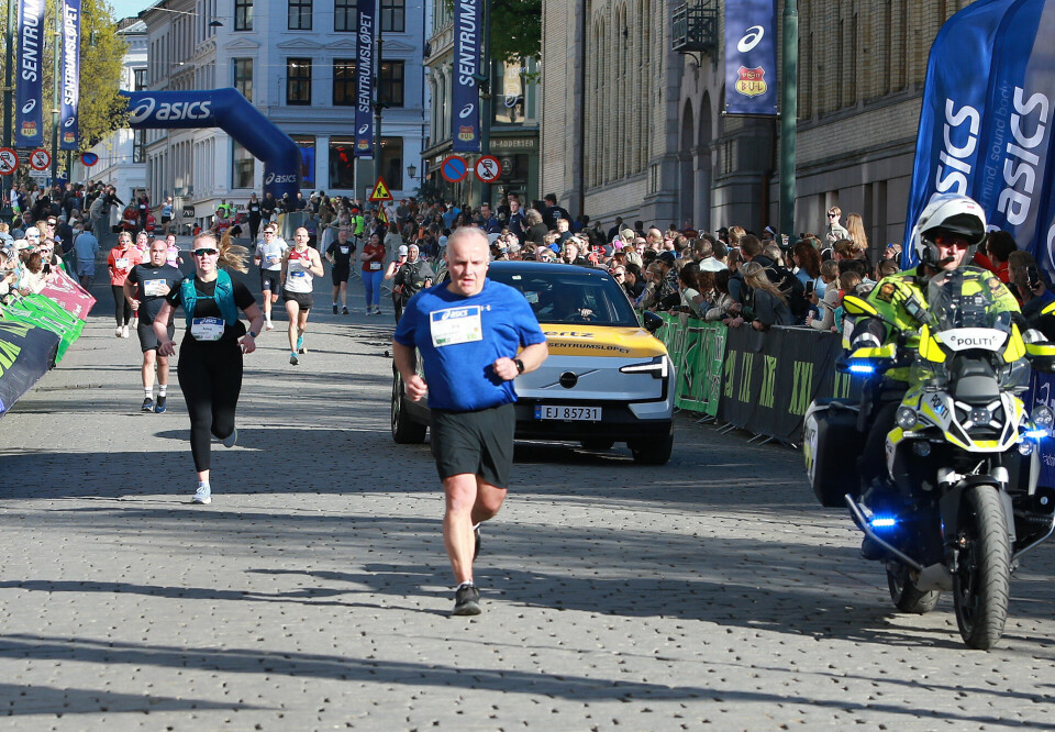 Teten på 5 km mot mål blant de siste på 10 km med følgebil og politisykkel sikk sakk mellom baktroppen på 10 km. Det var ikke lett å følge det spennende spurtoppgjøret på 5 km. Vi ser Mathias leder an spurten ned mot mål ved inngangen til Grand Hotel. (Foto: Kjell Vigestad)