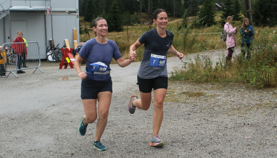 Caroline Nylund Øvsthus (til venstre) og Åse Sigrid Torp hånd i hånd mot mål på sin 10 km. Budor Løpefest 10 km Innlandet
