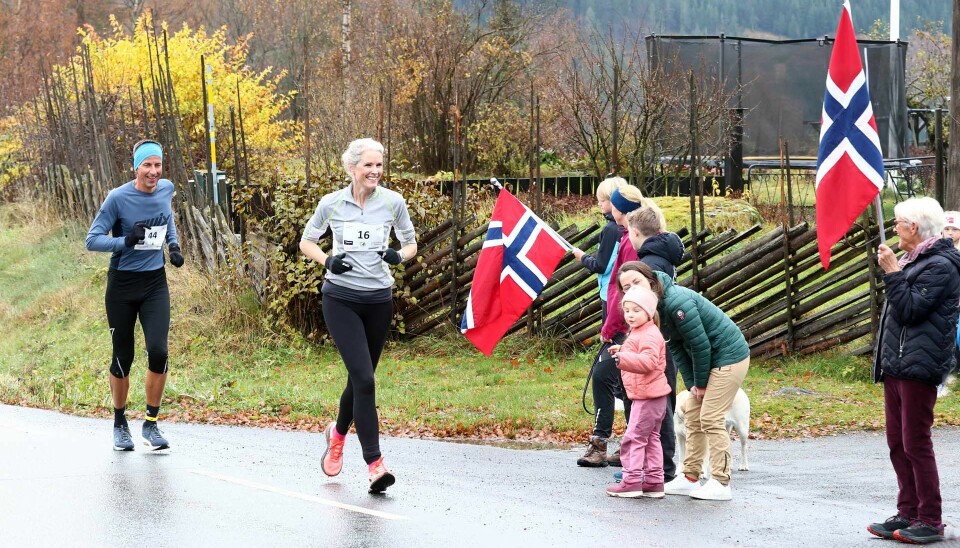 Det var både smil og flott stemning under løpet opp Musdalsbakkene. Her ser vi Rannveig Røstad fra Søre Ål IL passerer en ivrig heia-gjeng med flagg, her i følge med Kjetil Skjåk fra Lillehammer Skiklub.