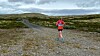 Raskeste kvinne, Hilde Dalen Jordet, med snaufjellet foran seg på halvmaraton.