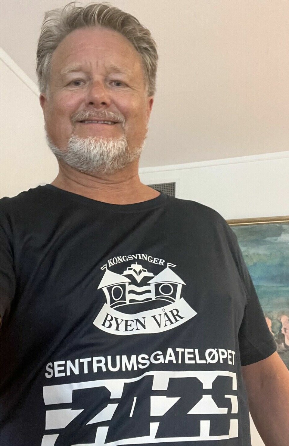 Uno Arnesen viser fram årets t-skjorte og ønsker velkommen til byen. (Foto: arrangøren)