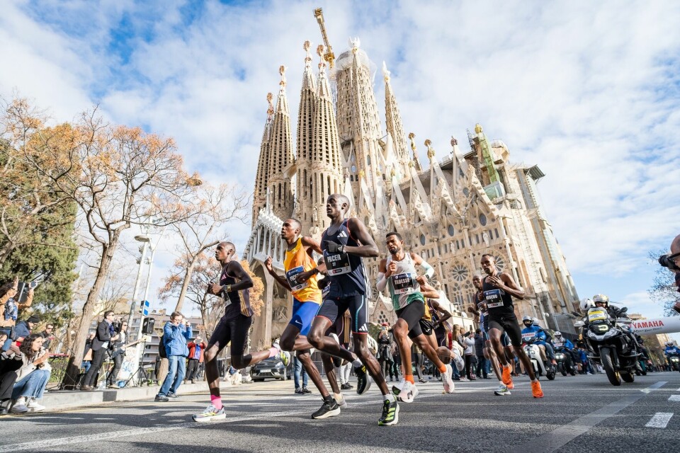 Vinner Tadesse Abraham ligger i rygg på fartsholderne idet teten passerer den mektige La Sagrada Familia-katedralen. (Foto: arrangøren) Vinner Tadesse Abraham ligger i rygg på fartsholderne idet teten passerer den mektige La Sagrada Familia-katedralen. (Foto: arrangøren)