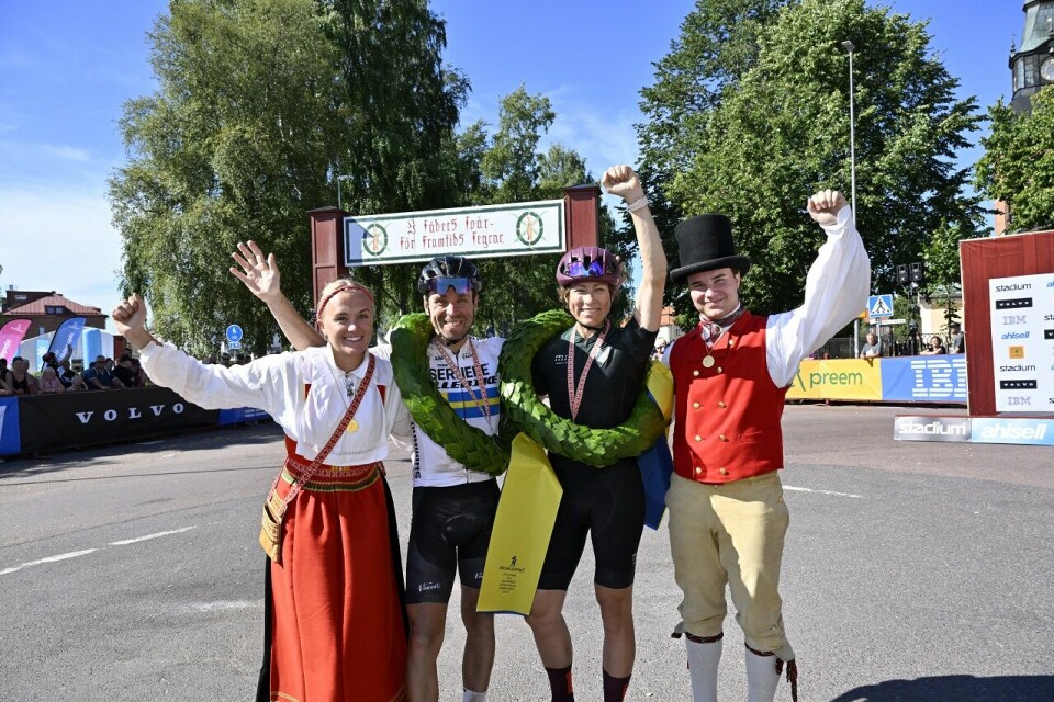 Vinnerne av Cykelvasan 2022, Emil Lindgren og Sandra Salinger, sammen med kranskullan og kransemasen. (Foto: Vasaloppet/ Nisse Schmidt) Mora 220813Cykelvasan Emil och SandraFoto Nisse Schmidt